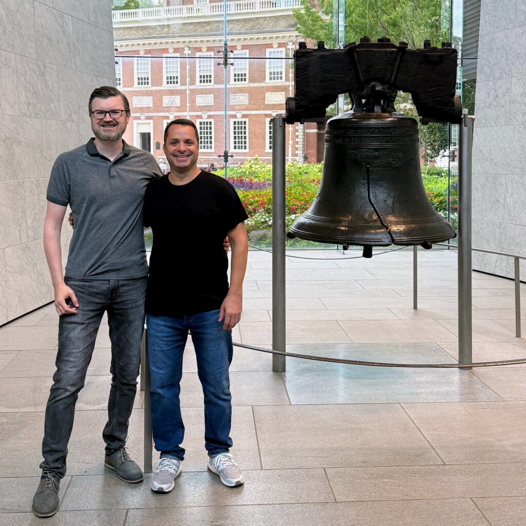 Shilo and Andrew smiling and standing next to the Liberty Bell.