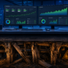 Dual monitors displaying healthy Google Ads performance dashboards with upward-trending green metrics, set on a desk above crumbling dry-rotted wooden support beams and a warning sign, illustrating the gap between a clean weekly report and hidden account structure problems.