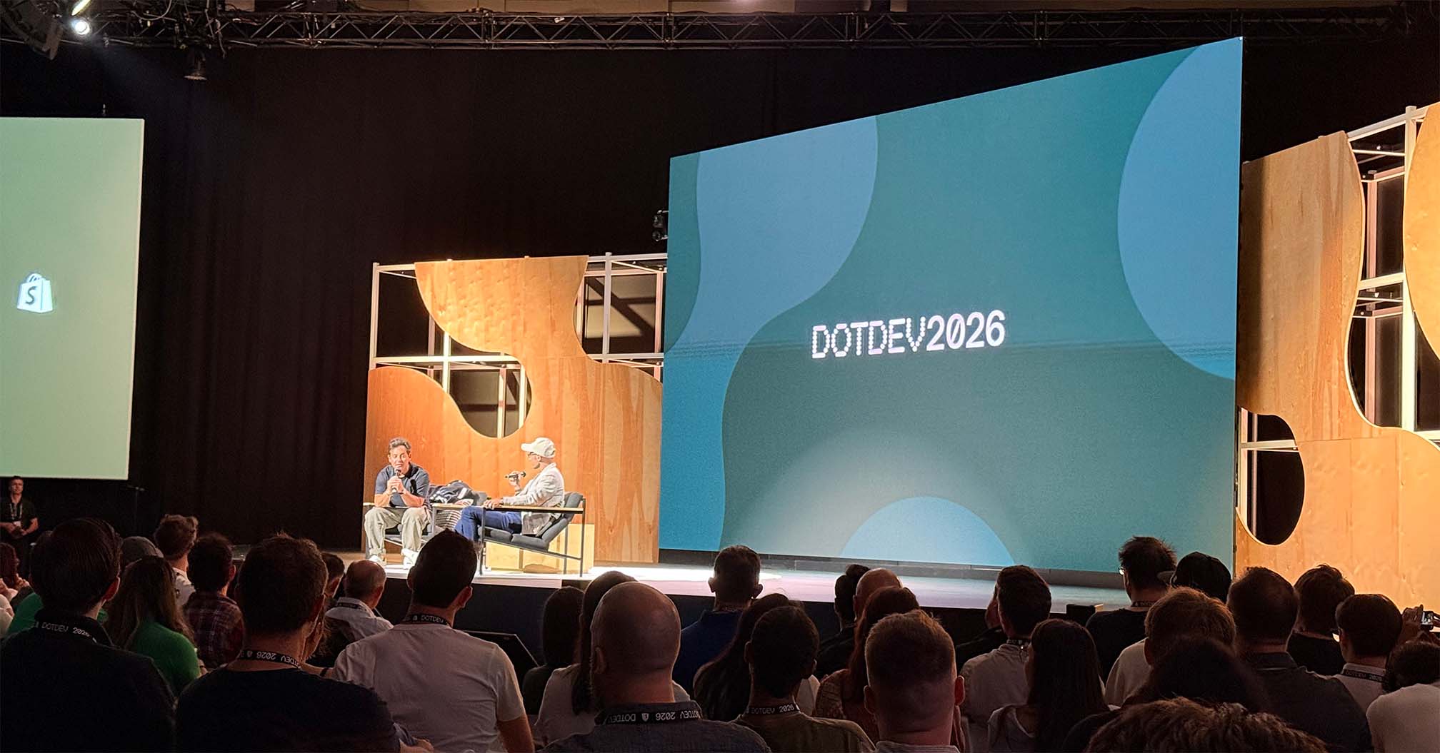 Two speakers seated for a fireside chat on the DotDev 2026 main stage